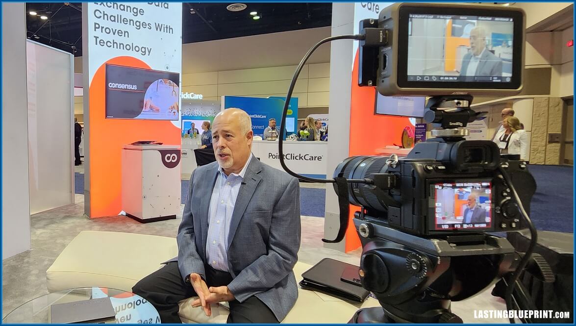 Man being interviewed on camera at expo booth.